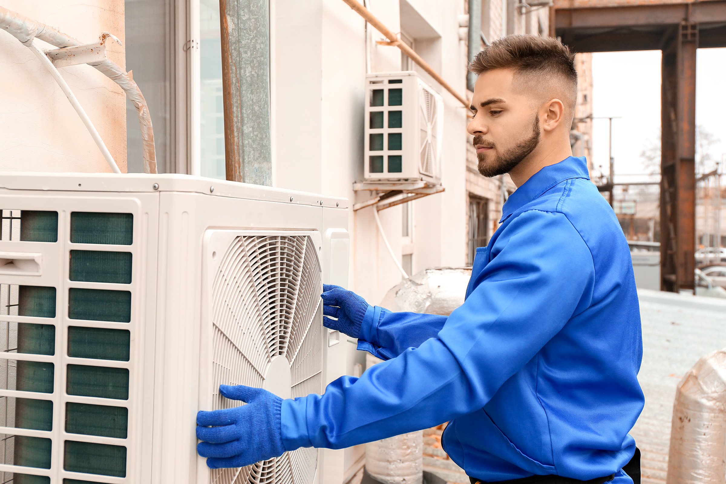 Technician installing an outdoor air conditioning condenser unit