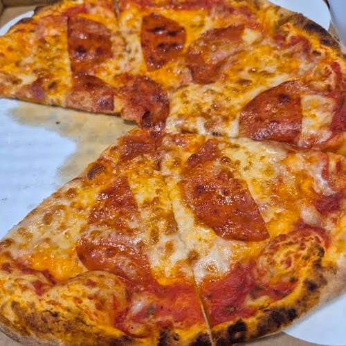 Pepperoni pizza with melted cheese and a crispy crust, partially eaten with one slice missing.