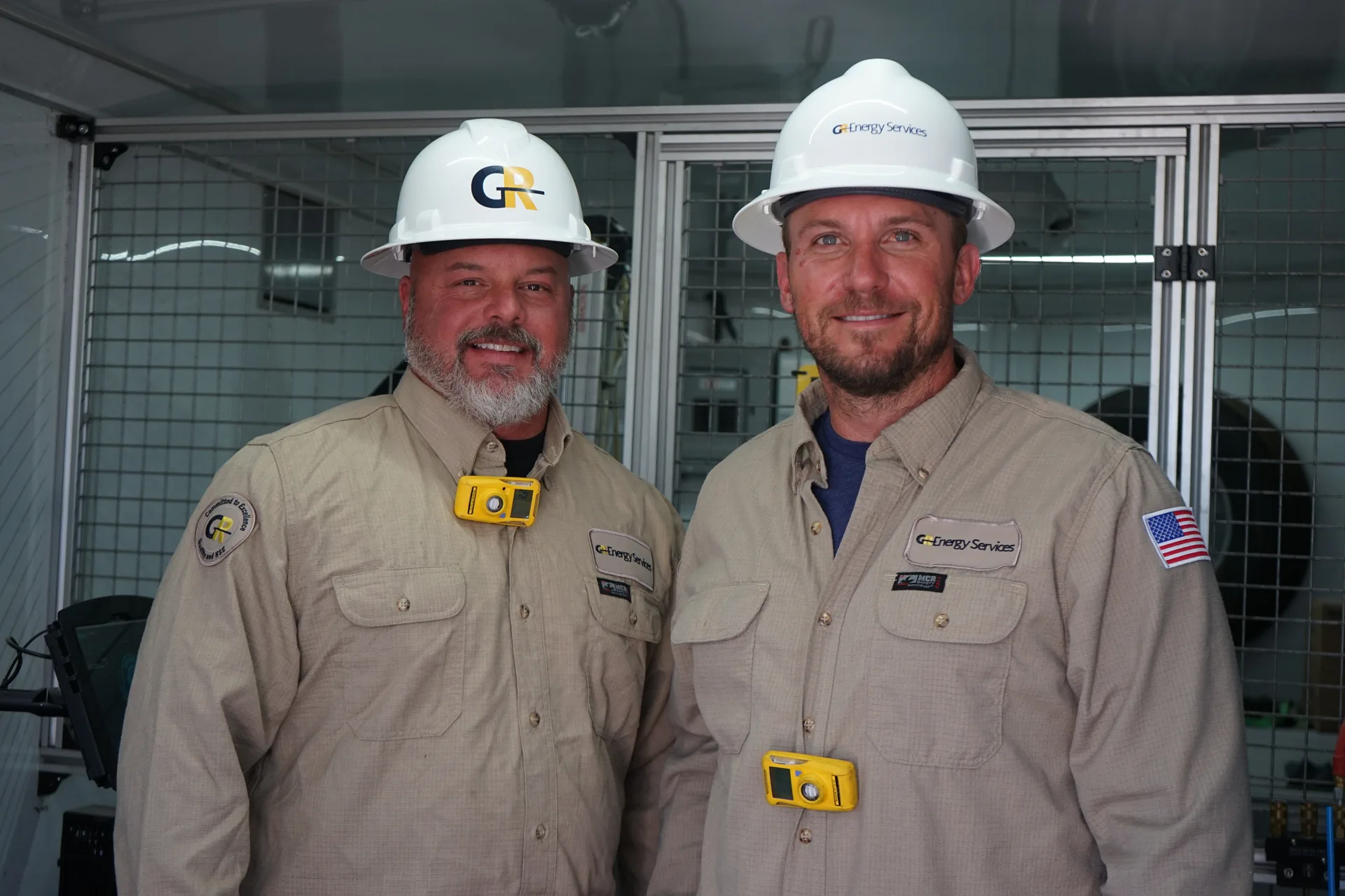 Two GR Energy Services crew members in hard hats
