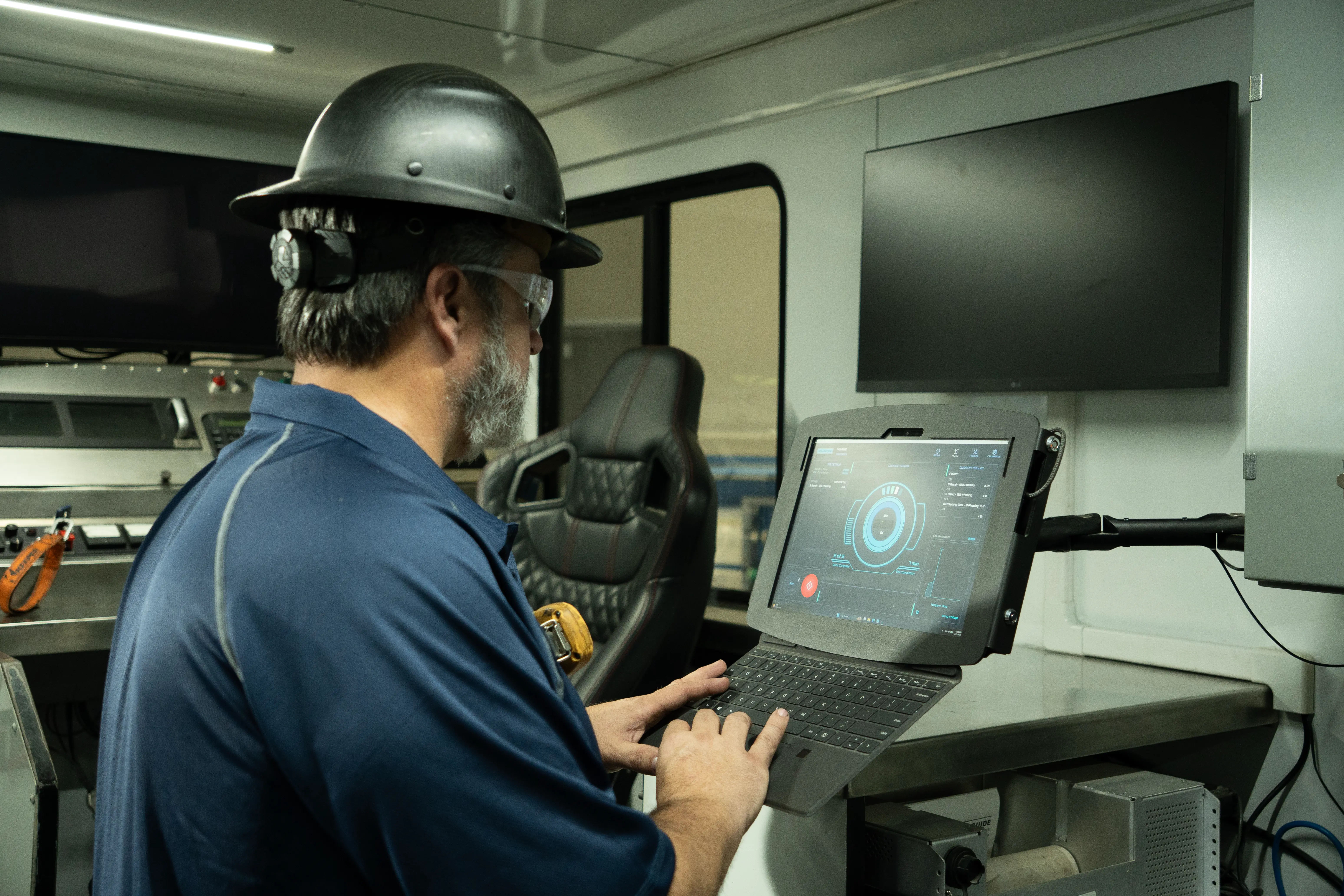 GR operator in a hard hat at a wireline unit control station