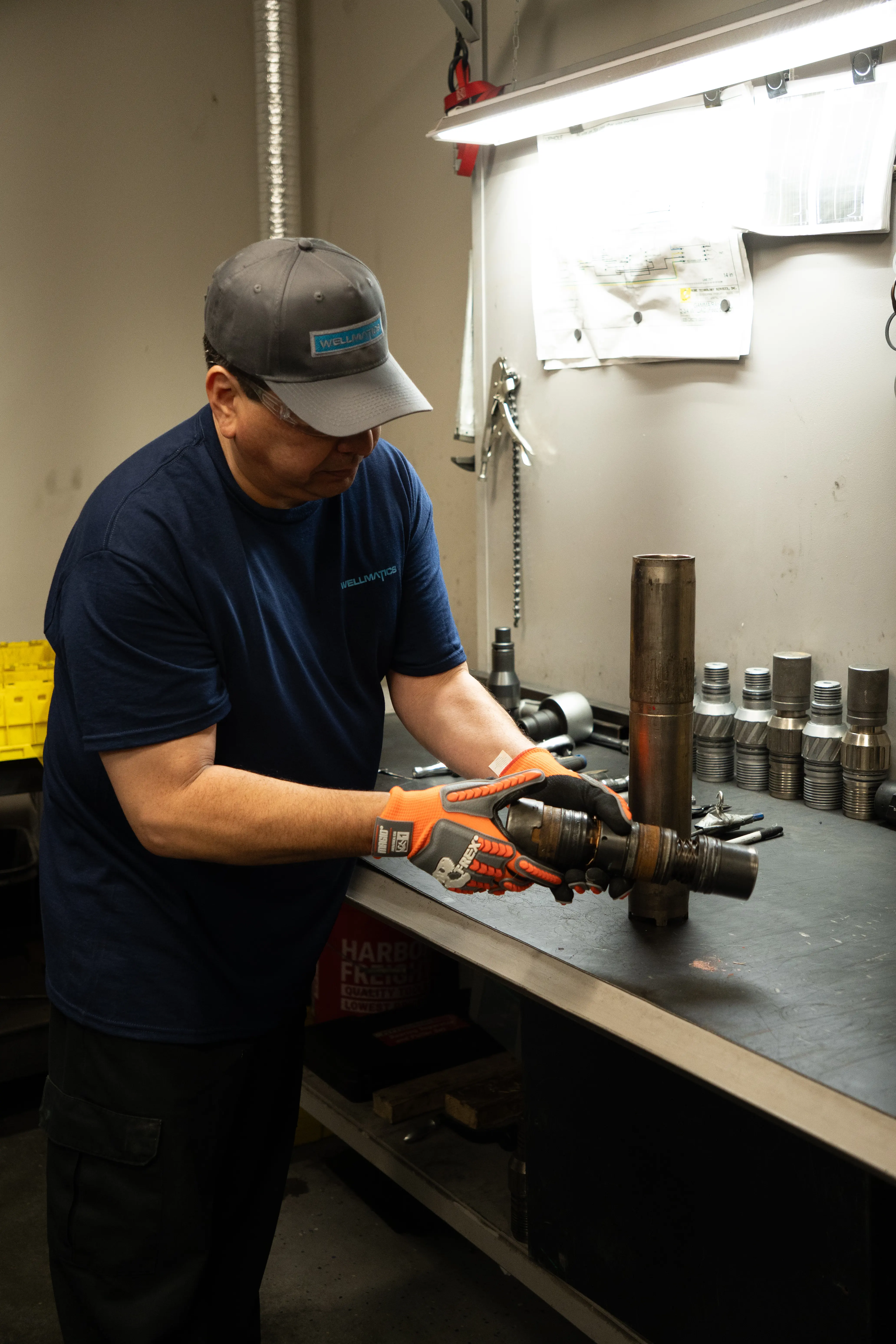 Technician assembling perforating gun components at a workbench