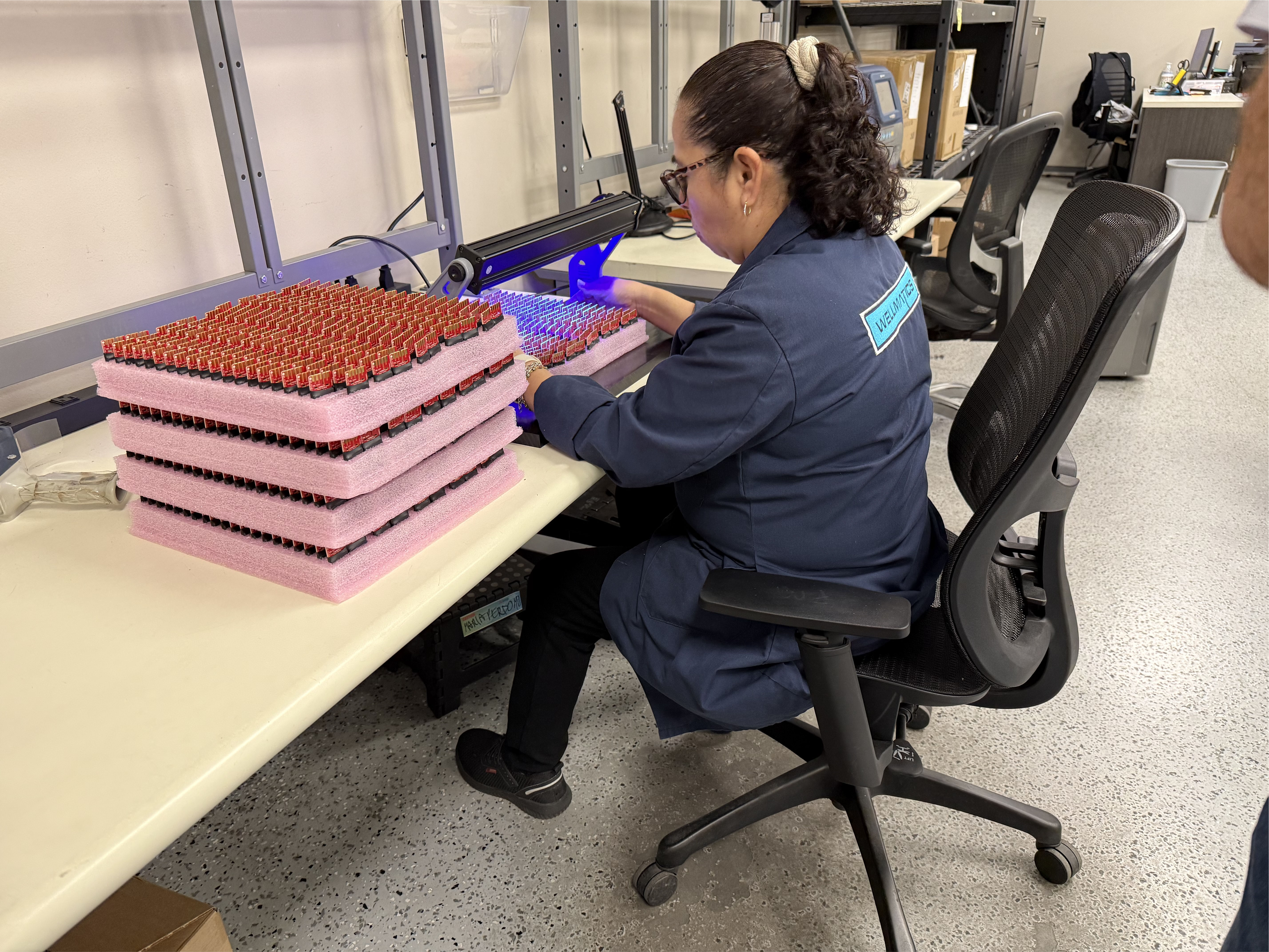 Technician inspecting trays of shaped charges