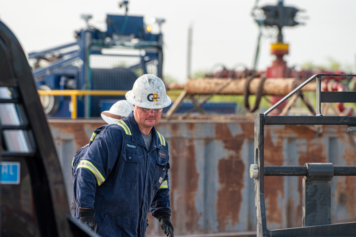 GR crew member in coveralls and hard hat on location