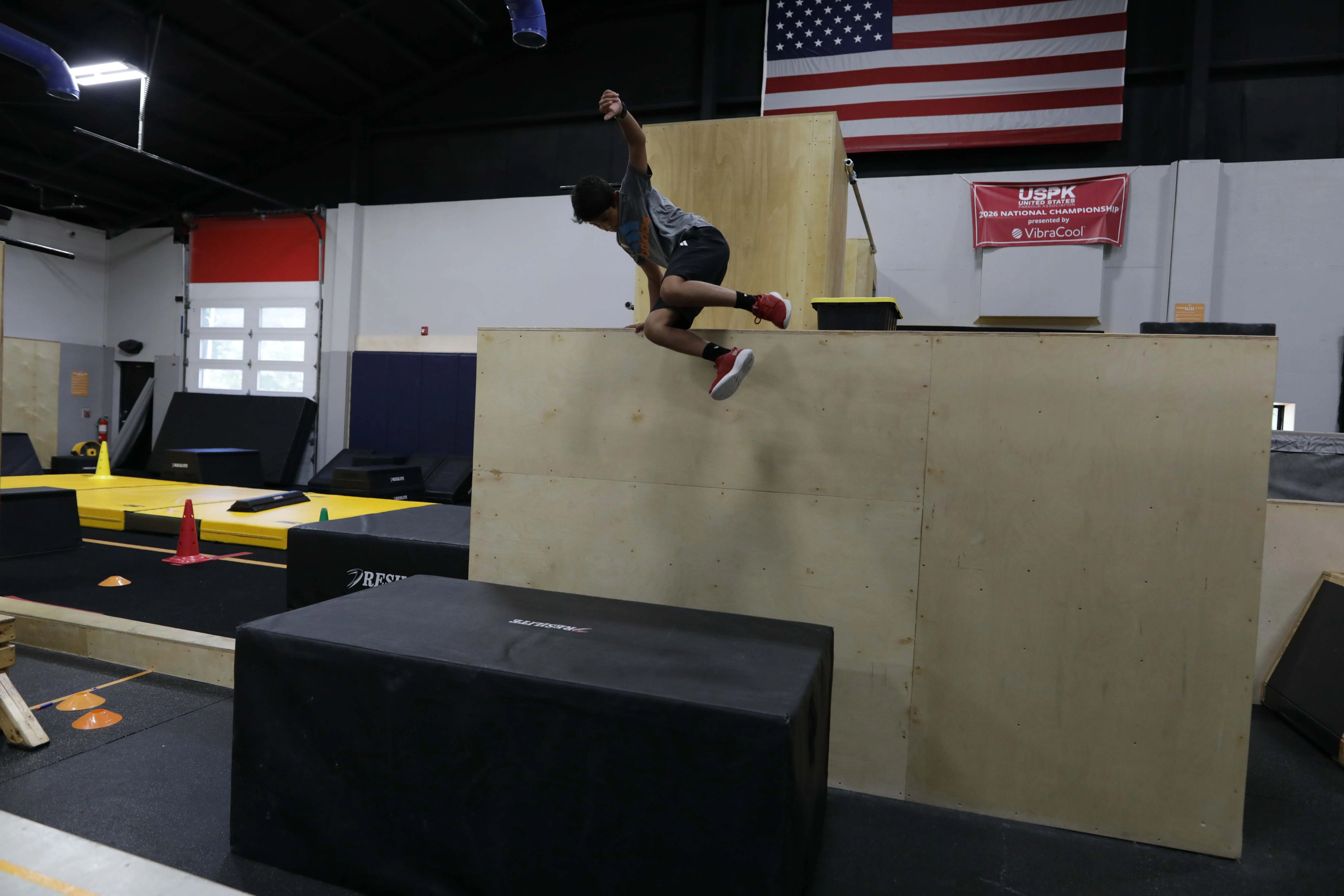 An athlete in athletic clothes and sneakers training at HUB Parkour
