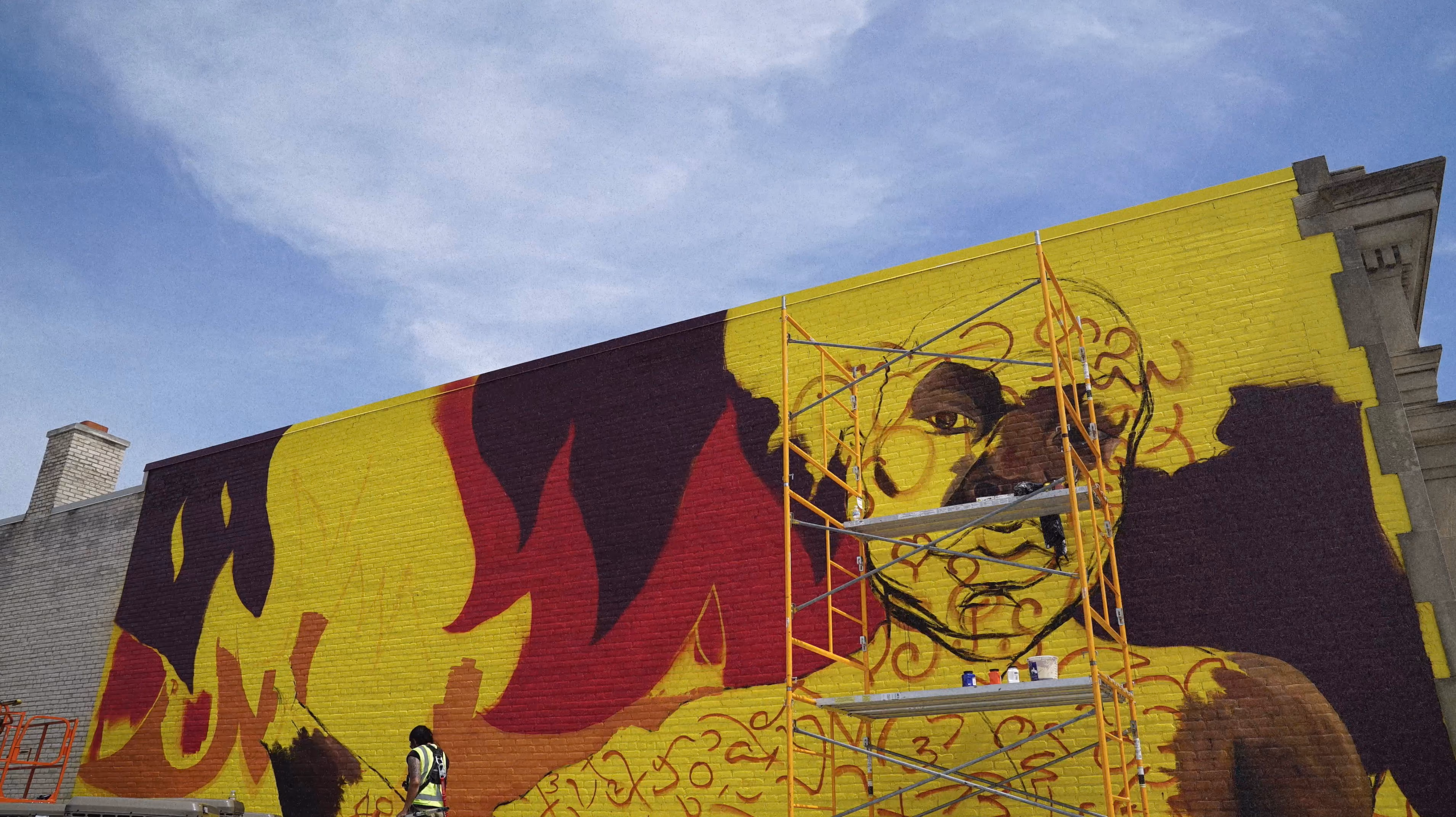 Sydney G James at work on the large-scale mural