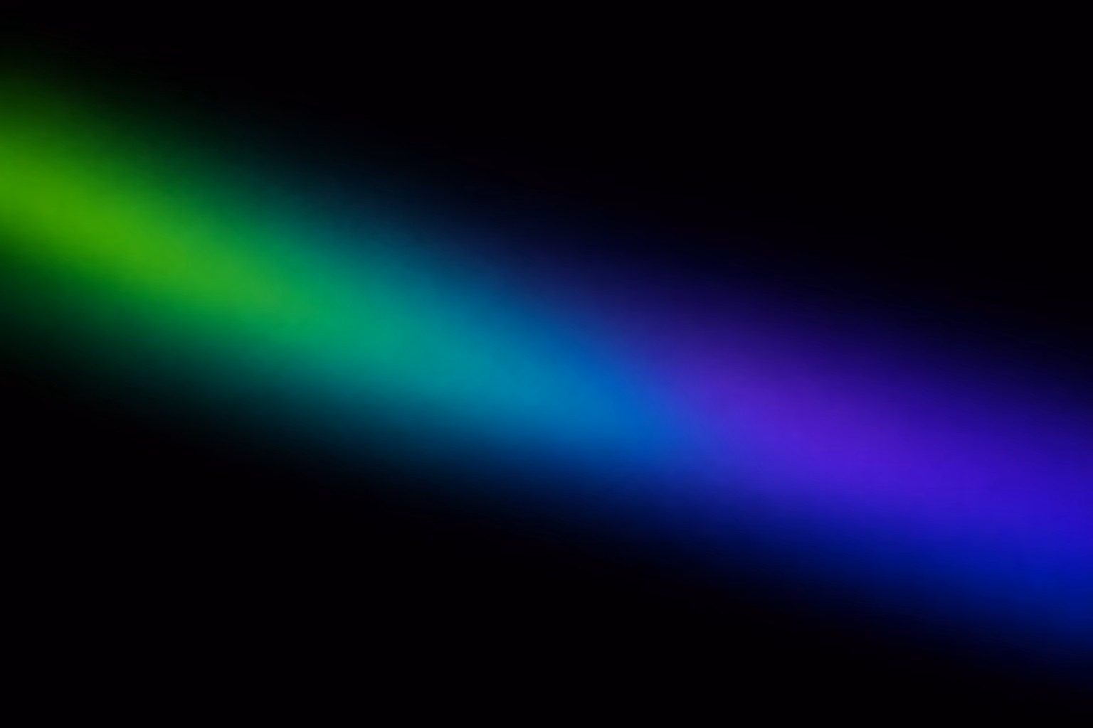 Diagonal gradient beam of light fading from green to blue to purple on a black background.