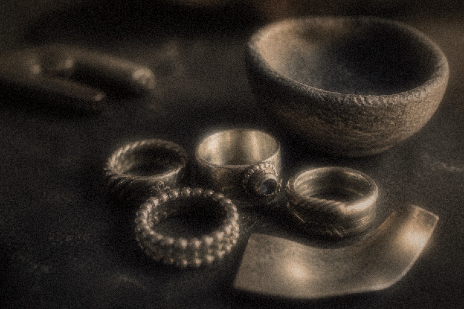 Patterned sterling silver rings on a reflective surface