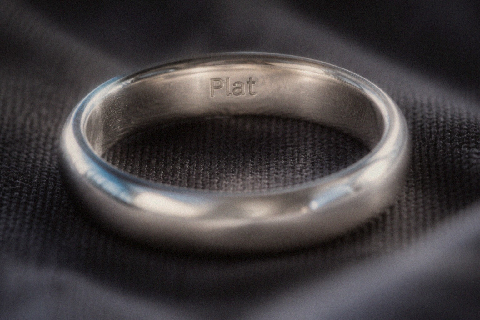 Diamond solitaire ring next to a white metal bracelet