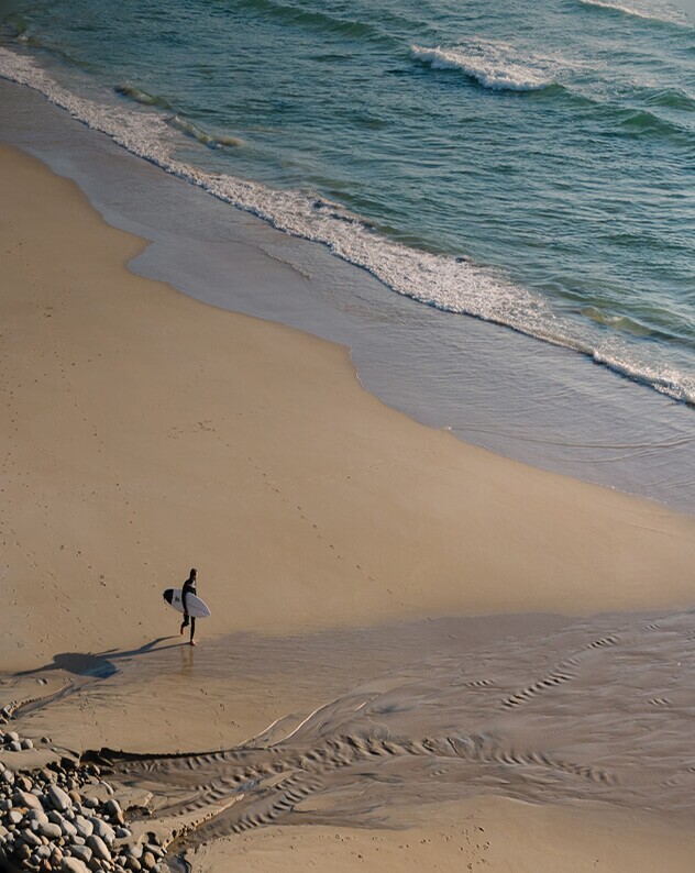 A person walking alone along the shoreline