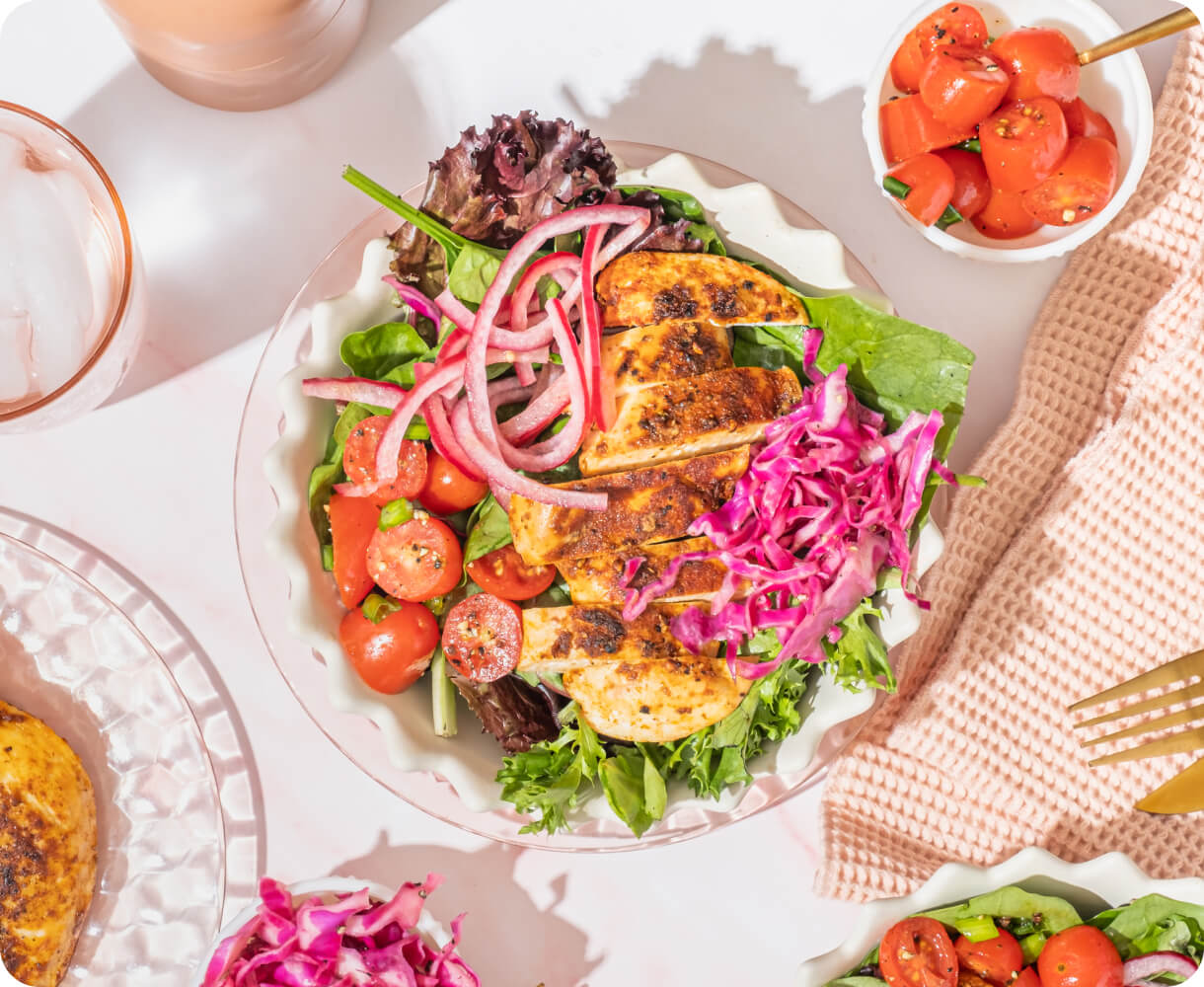 A plated chicken and vegetable salad on a table