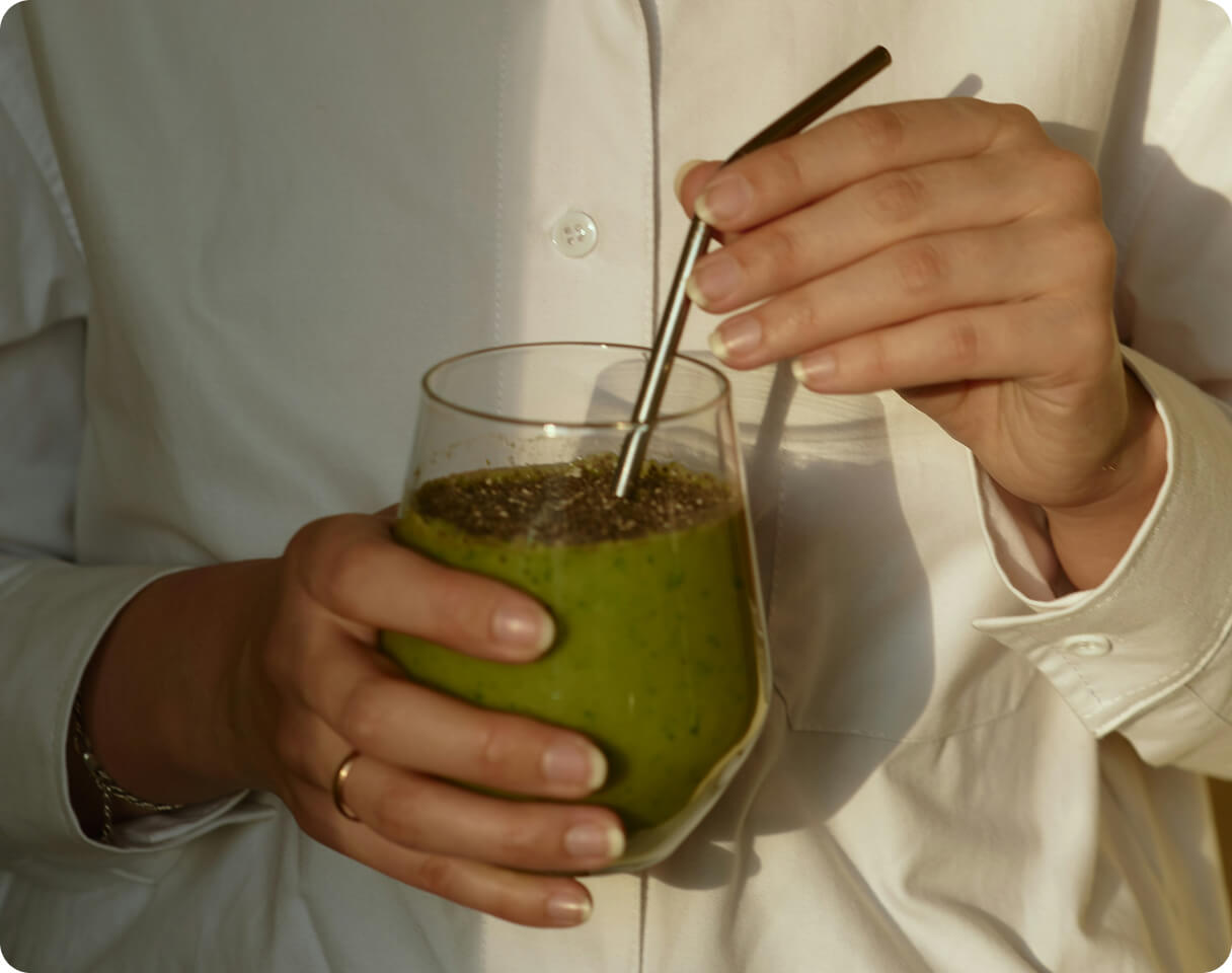 A person holding a green smoothie