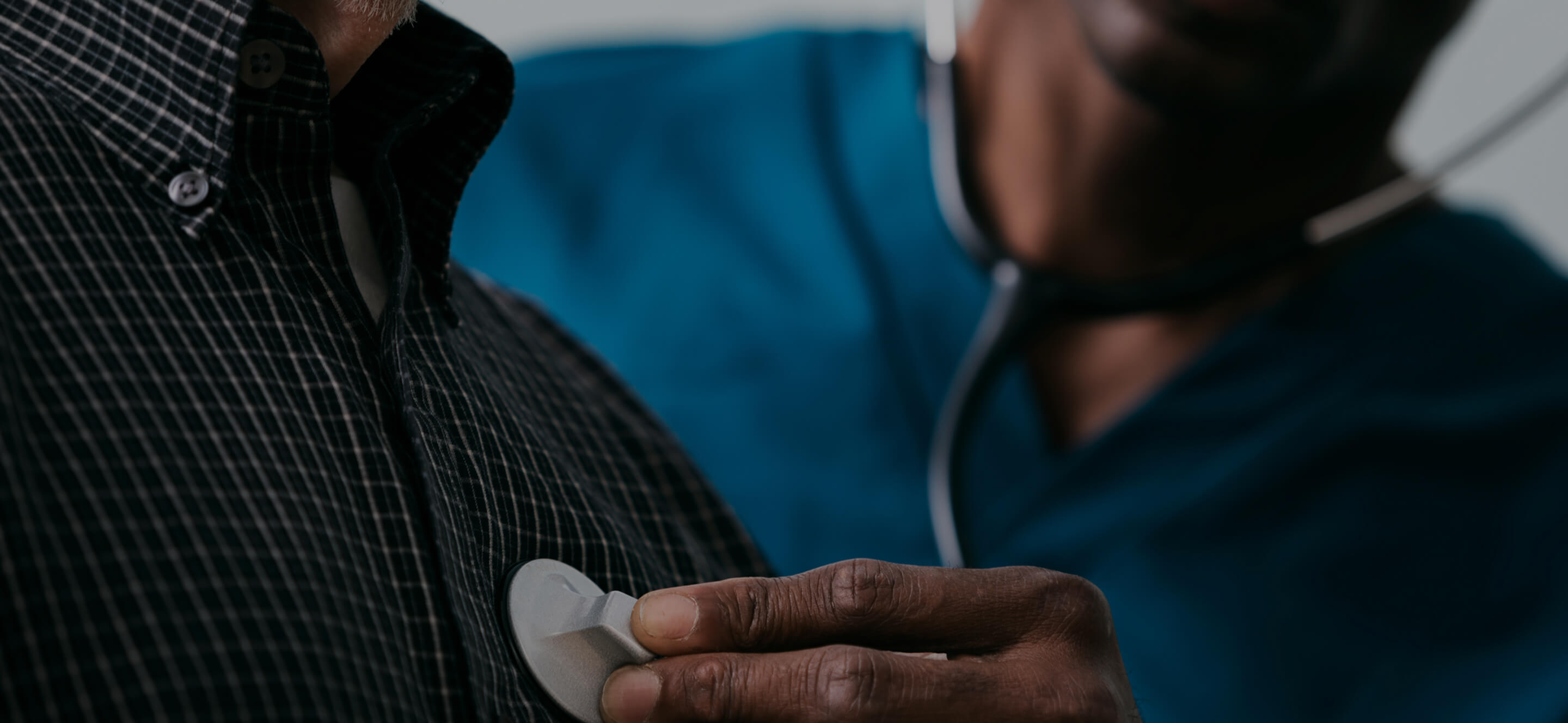 A clinician listening to a patient's chest with a stethoscope