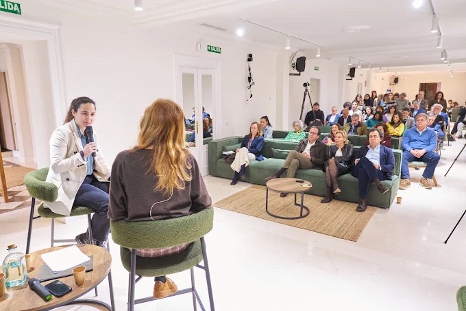 Conversación con asistentes sentados en sofás verdes en Noaway