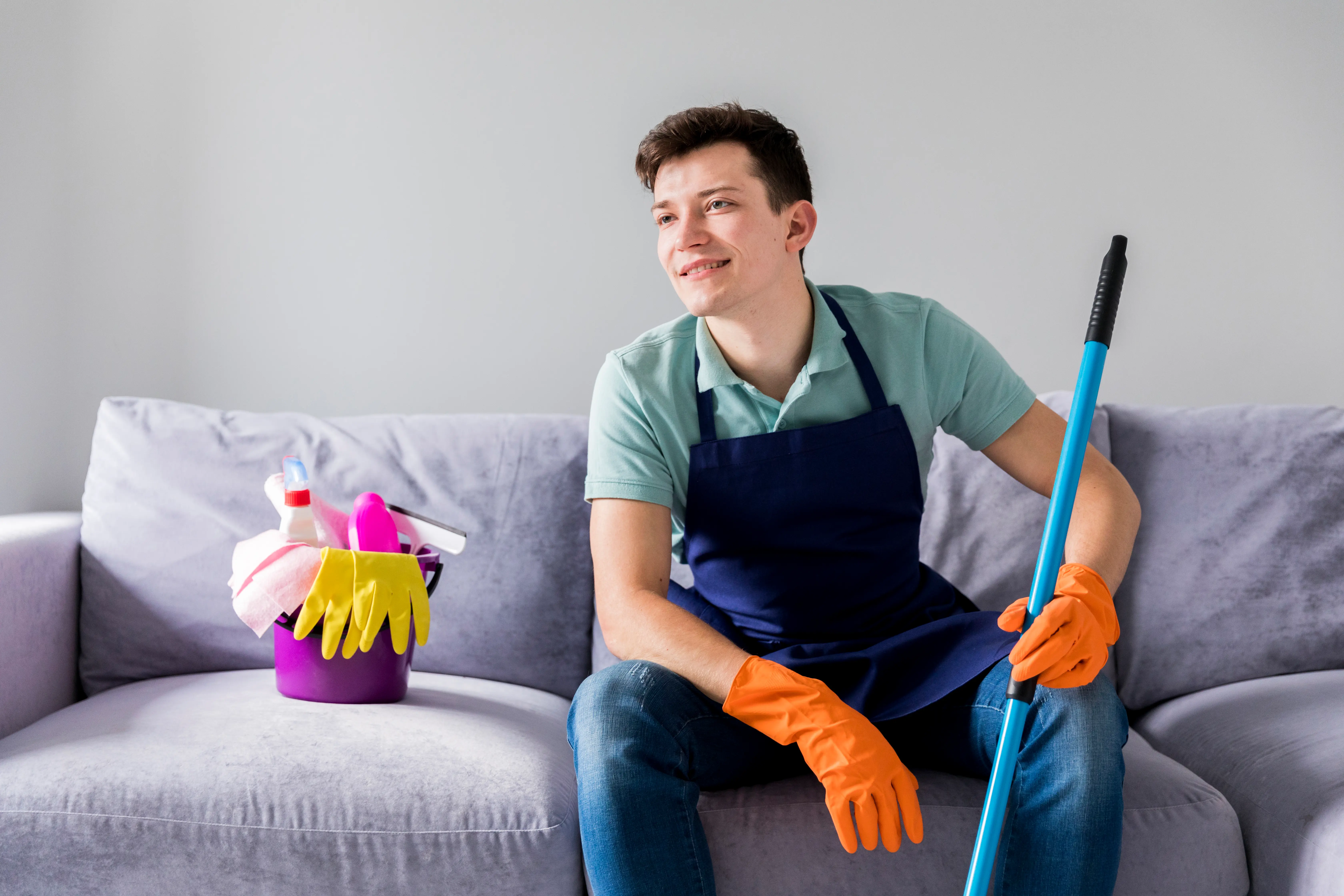 A person holding a bucket full with some cleaning tools