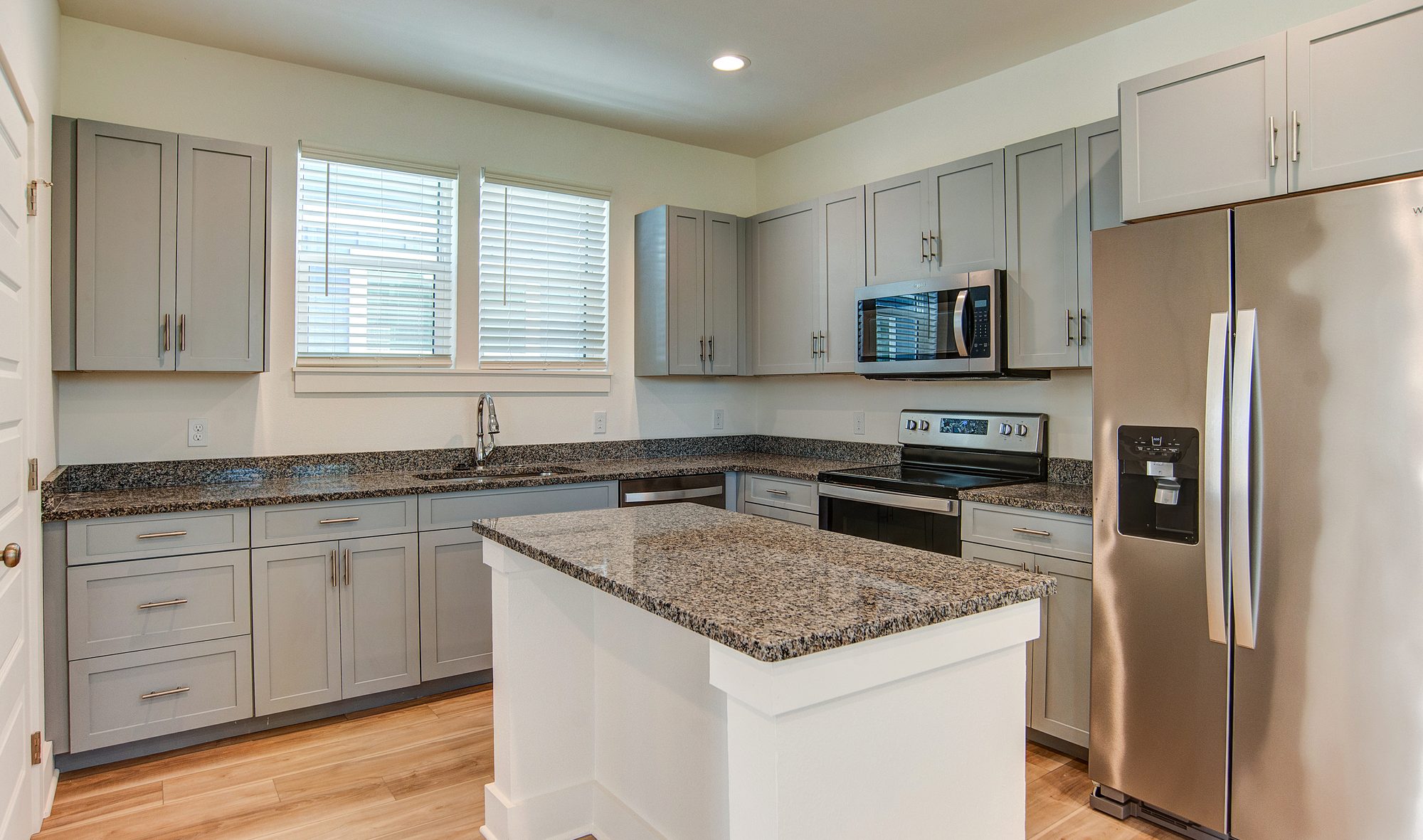 Kitchen with granite island and stainless appliances in a Barefoot Cottages home