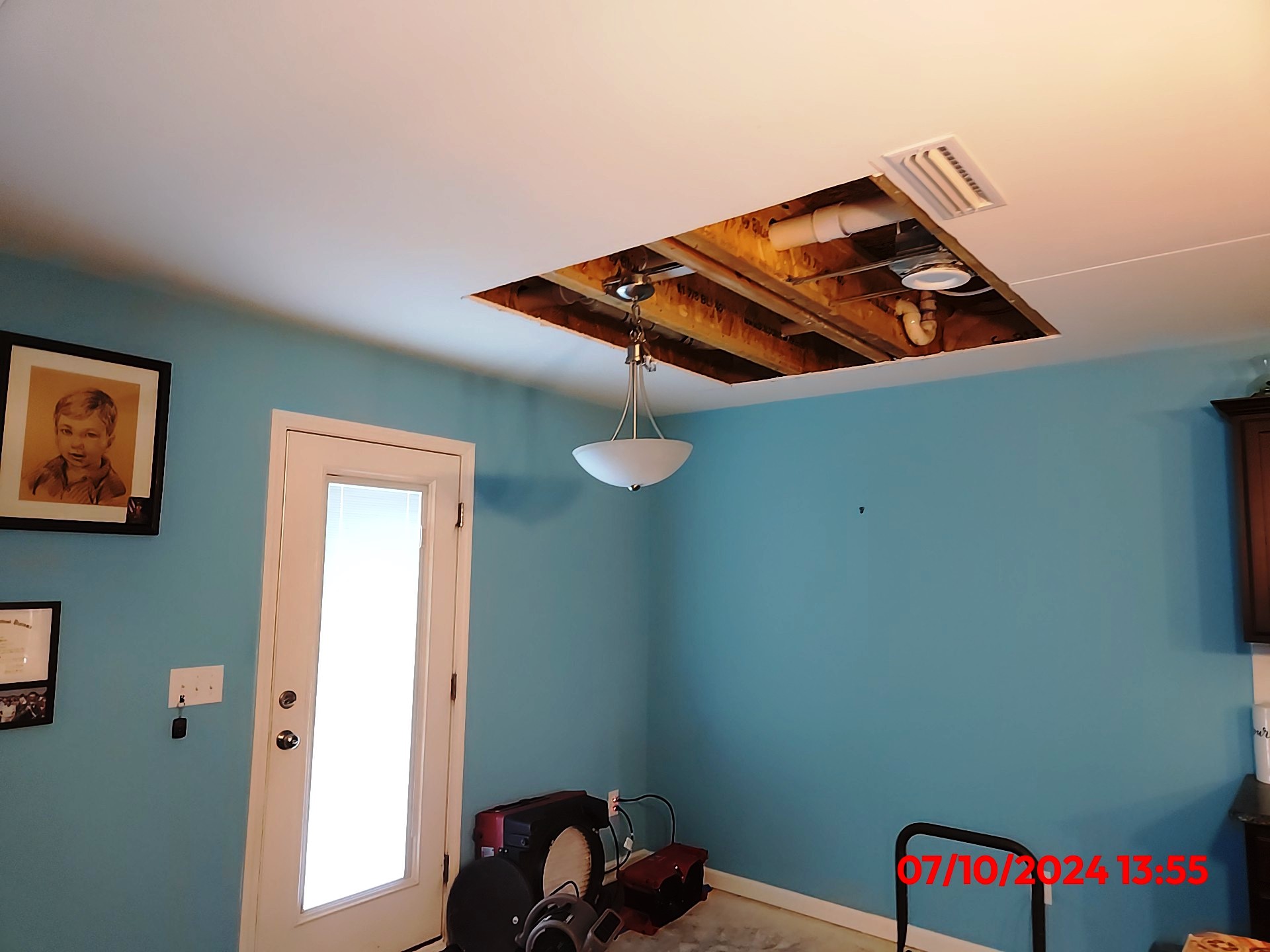 Ceiling drywall opened after a water leak in a Charlotte-area home, before repair