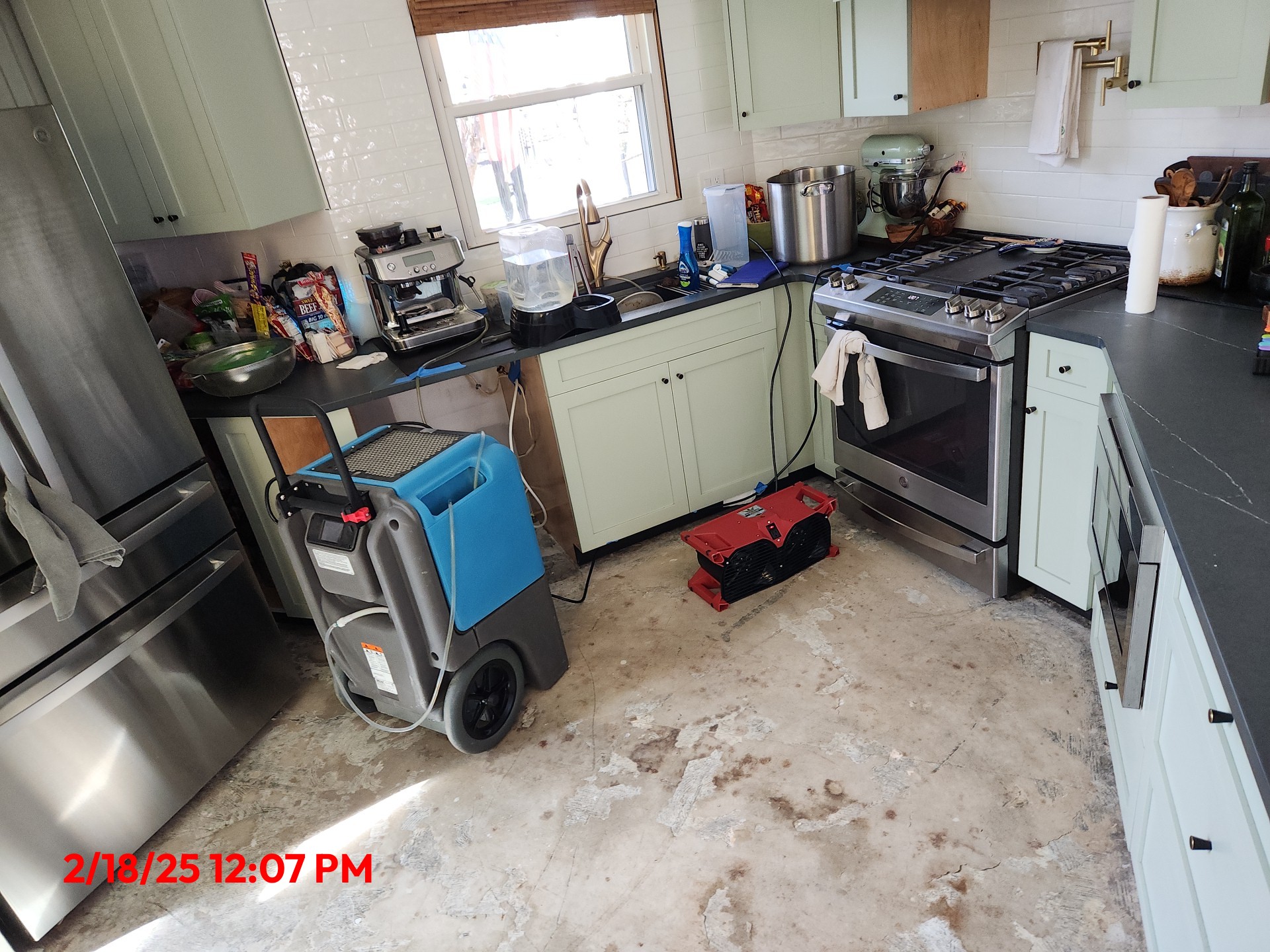 Kitchen with flooring removed and a dehumidifier in place after water damage