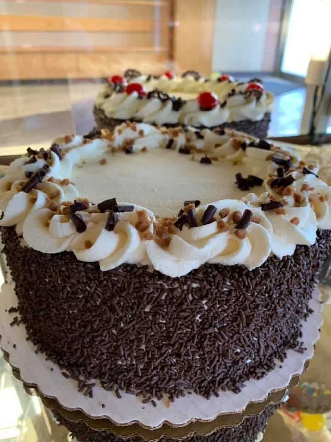 A Skor cake topped with cream rosettes, toffee bits and chocolate shavings