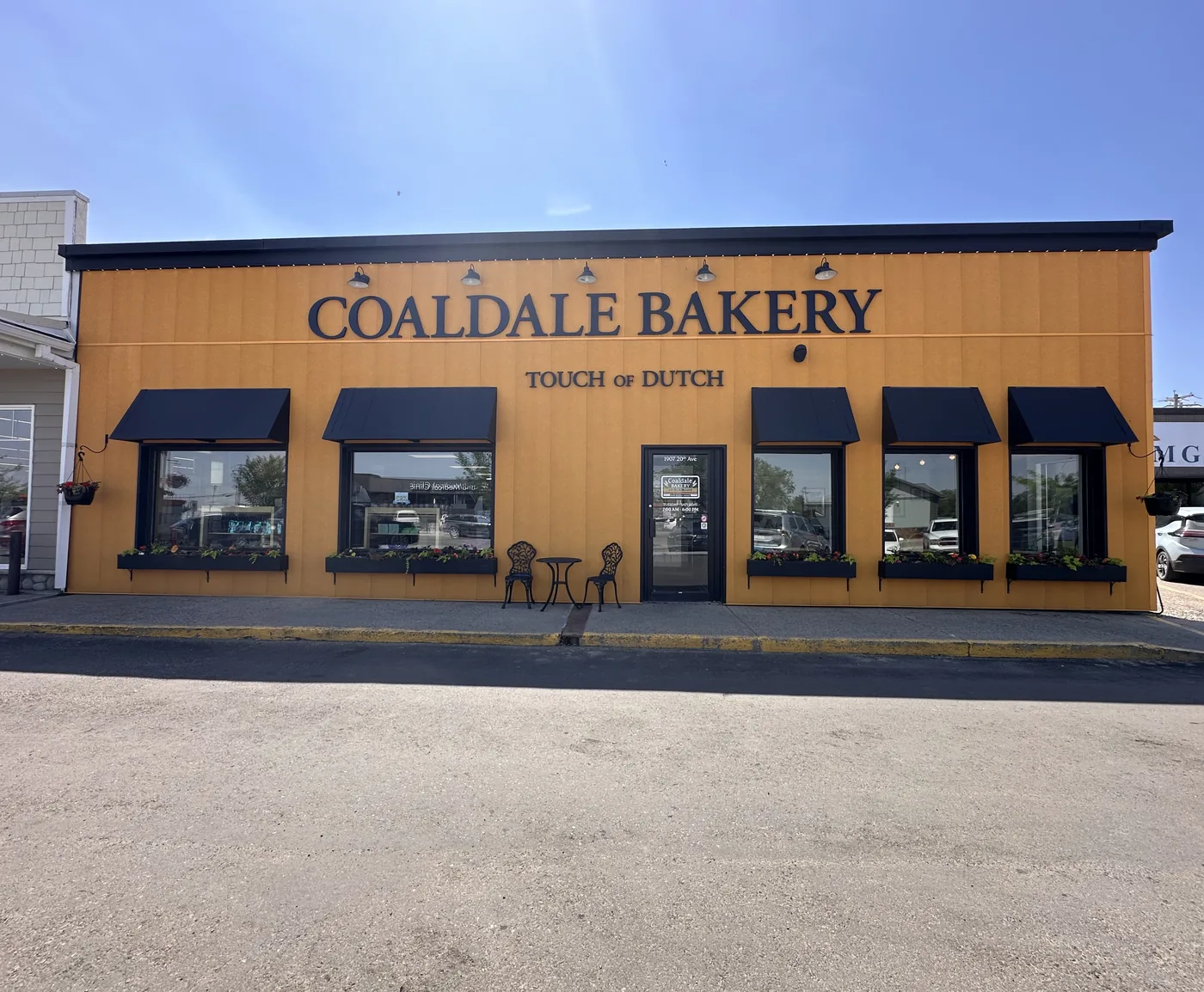 The Coaldale Bakery storefront on 20th Avenue, an orange building with black awnings and window boxes