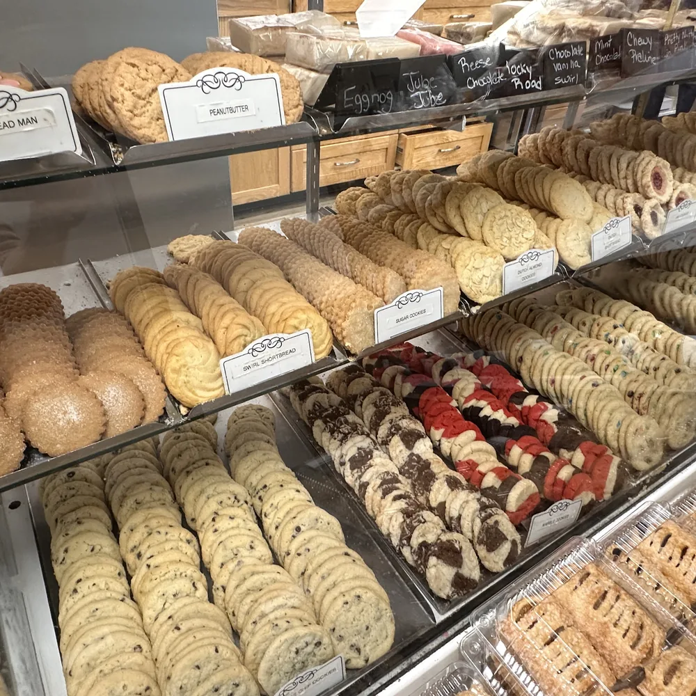 The bakery display case filled with trays of assorted cookies