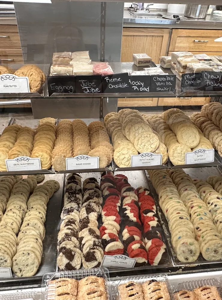 Trays of cookies and pastries on the shelves of the bakery display case