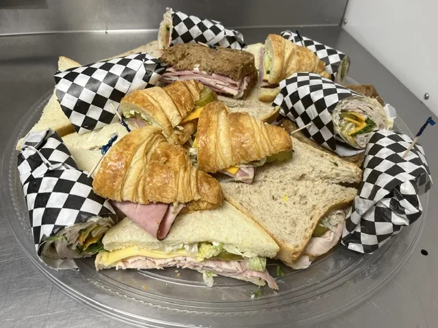 A tray of assorted sandwiches, wraps and croissants