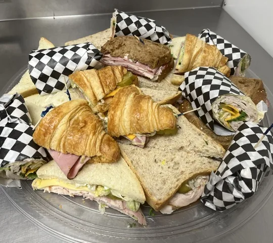 A platter of assorted sandwiches, croissants and wraps