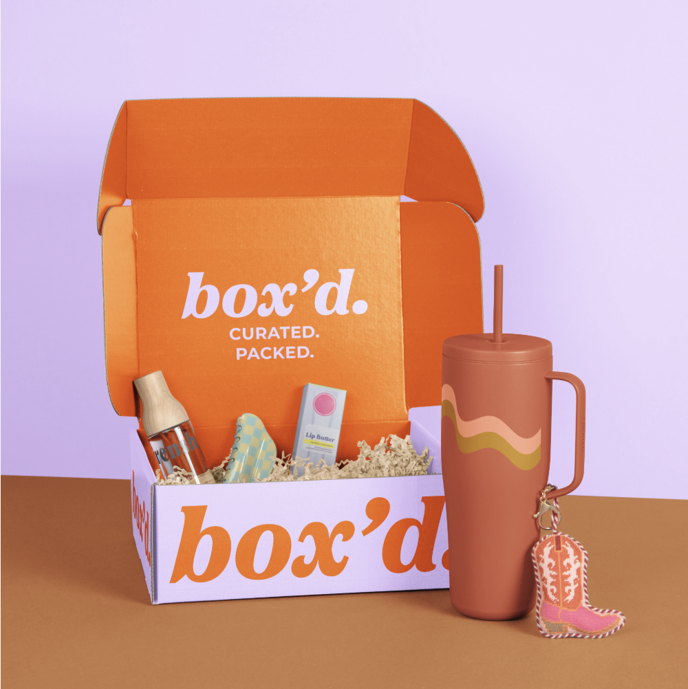 A small branded gift box tied with ribbon, styled as a curated client gift ready to send