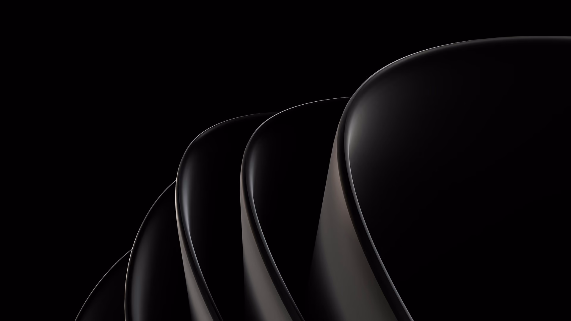 Close-up of four overlapping black curved surfaces with subtle lighting against black background.