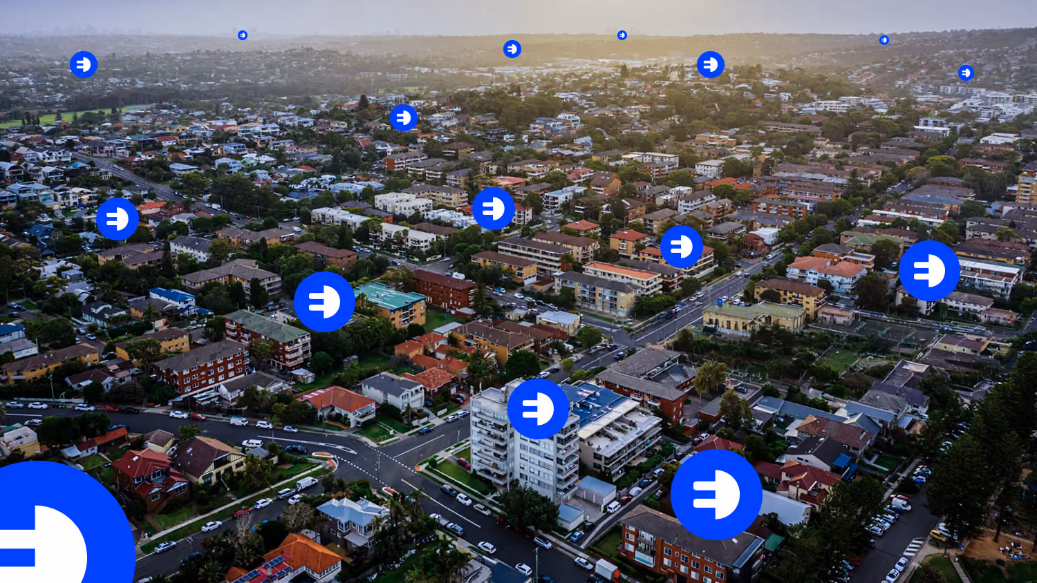 Aerial view of a suburban neighbourhood with blue location markers scattered across the area.