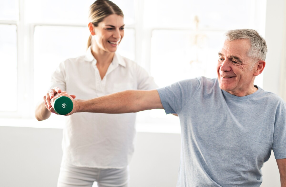 A registered physiotherapist working with an older adult at home