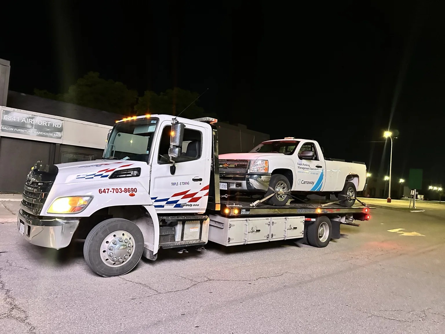 Pickup truck on flatbed tow truck