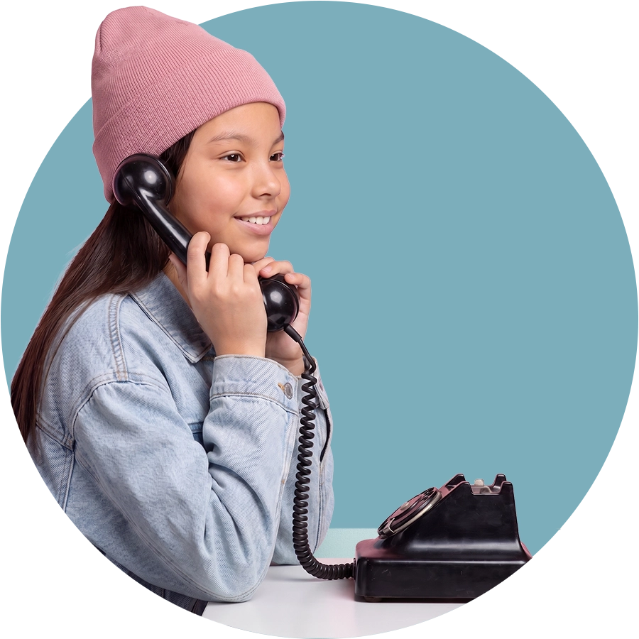 Girl smiling while talking on a retro telephone