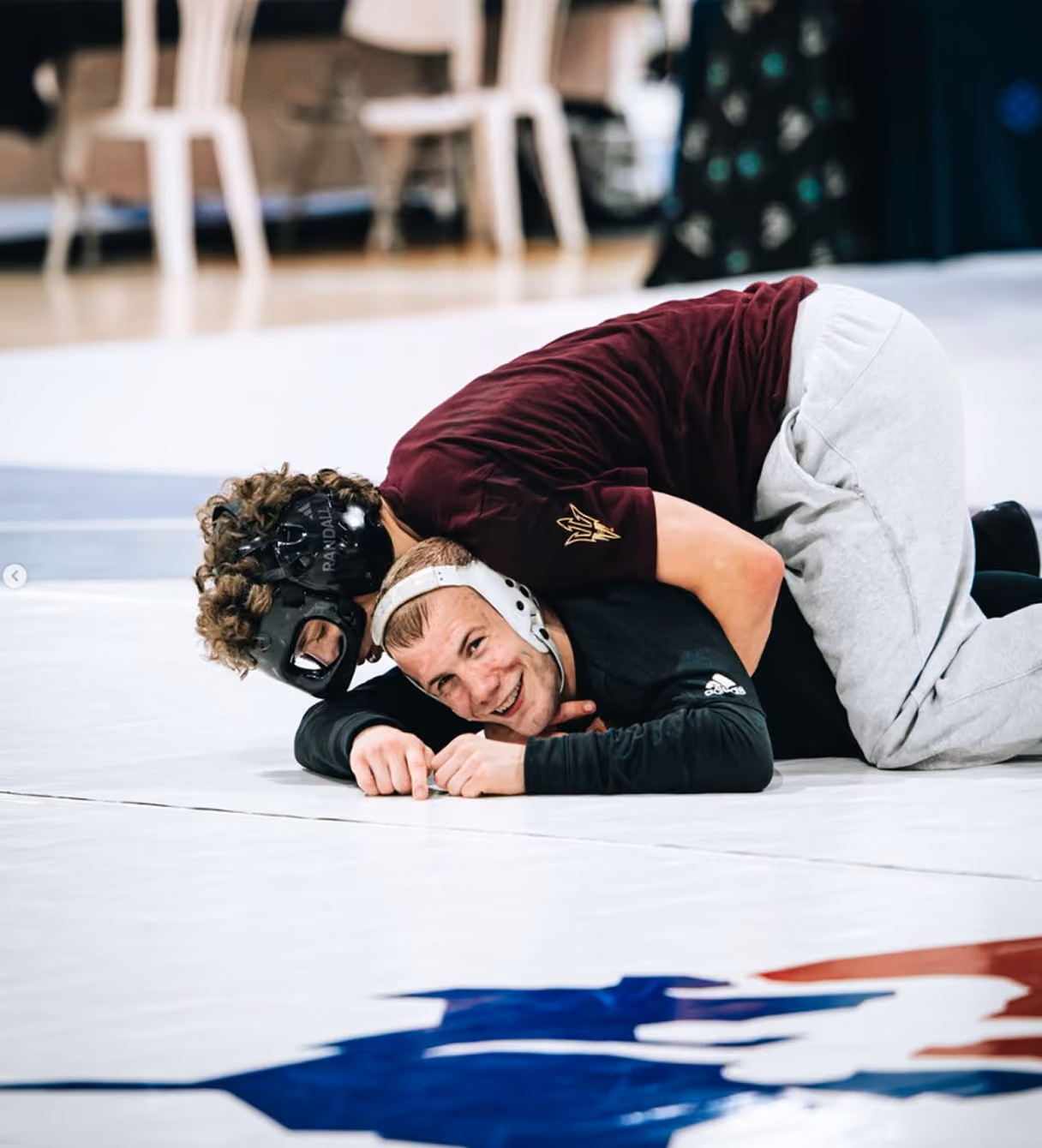Two wrestlers training together on the mat