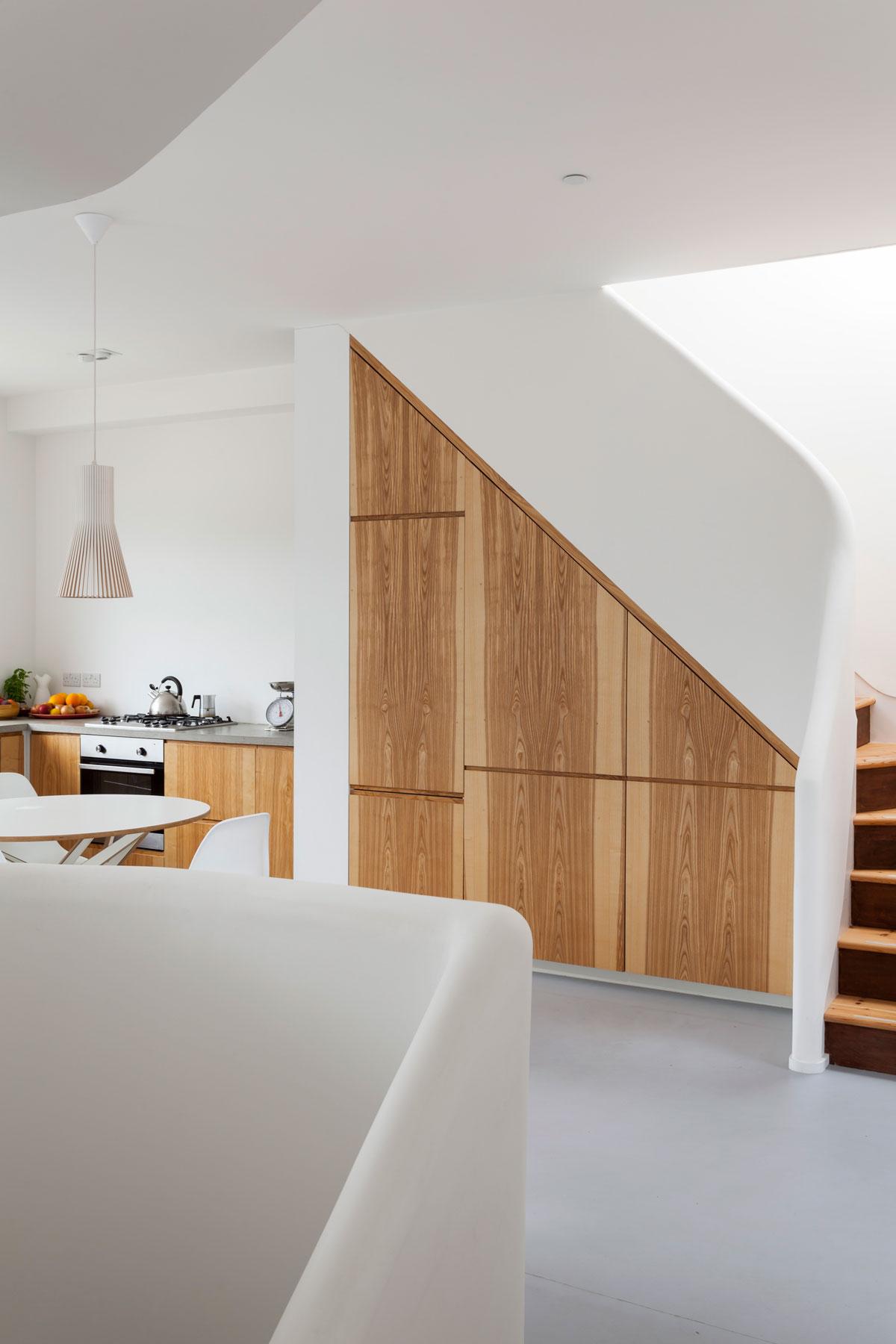 Kitchen and dining area beside full-height oak storage built into the stair
