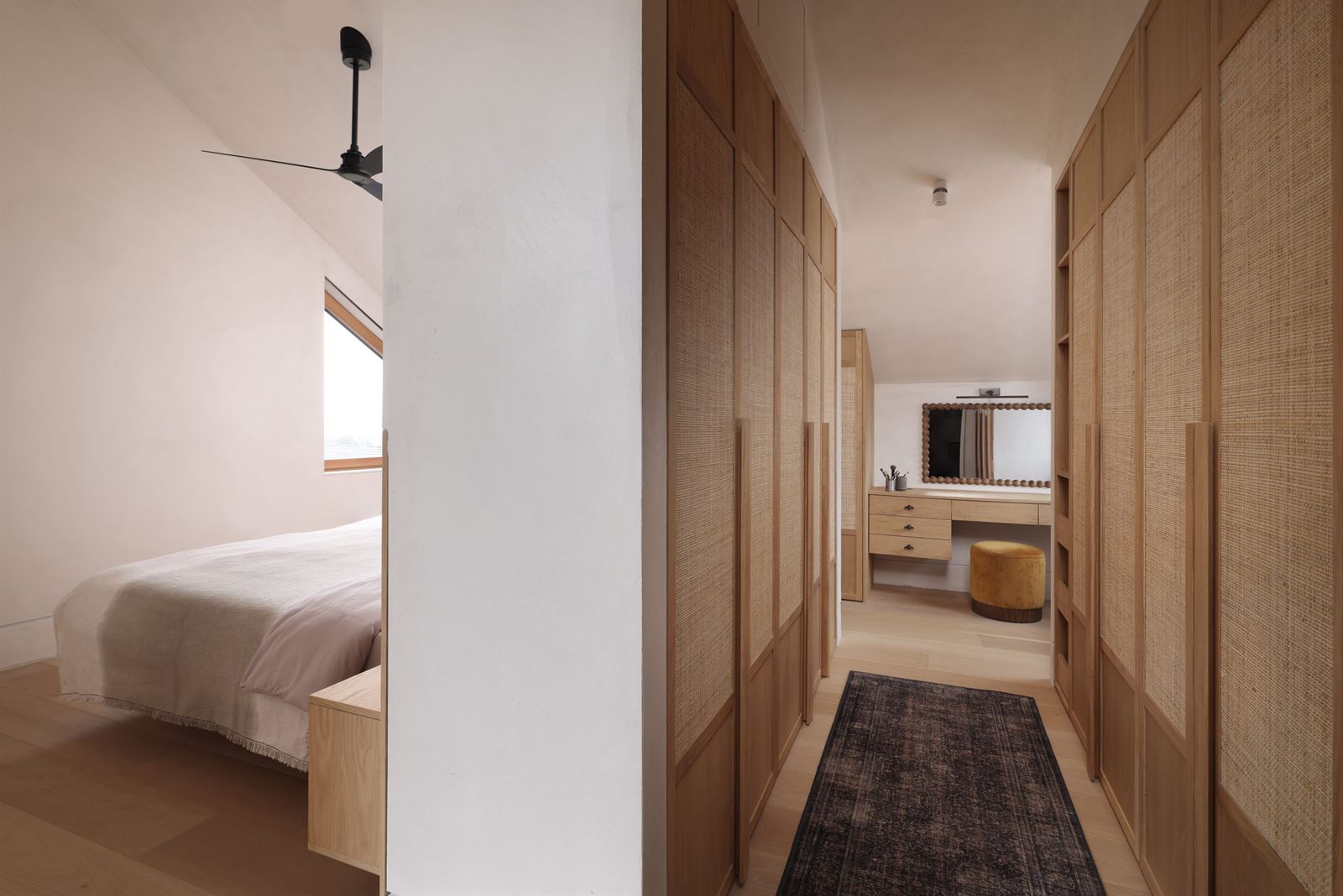 Dressing area with rattan-fronted wardrobes, seen past the bed