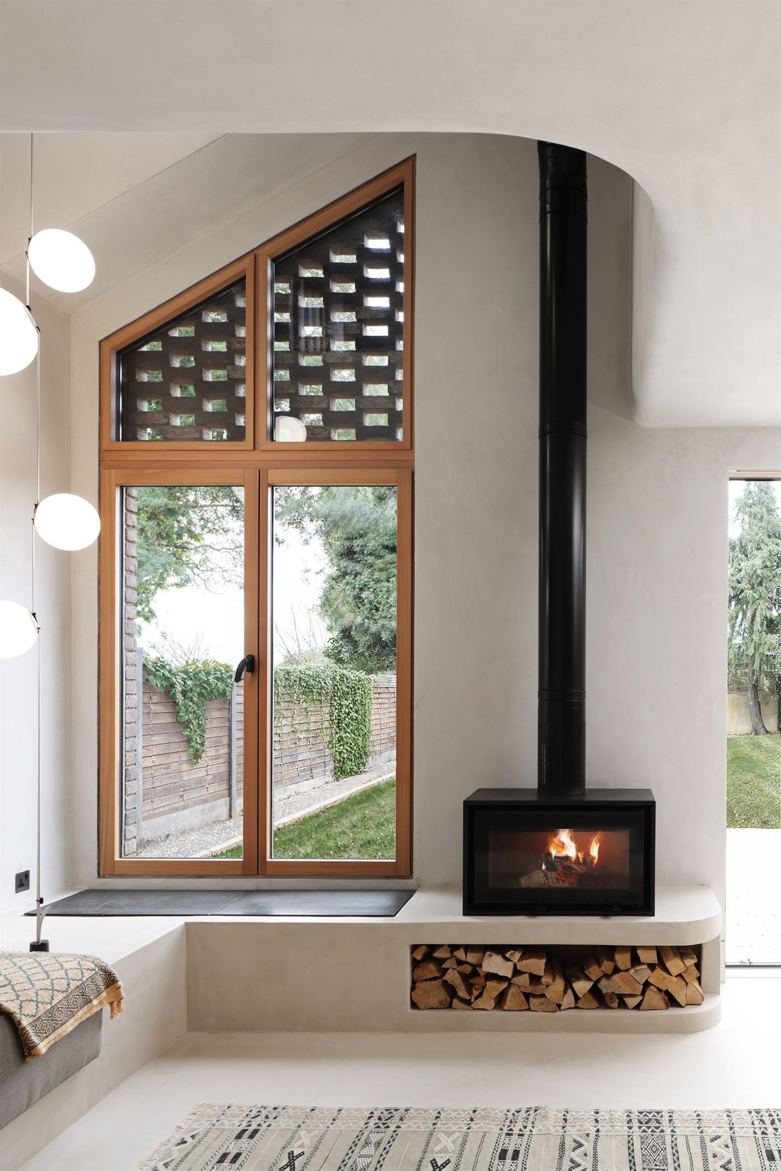 Tall timber-framed window with a brick lattice panel above the window seat