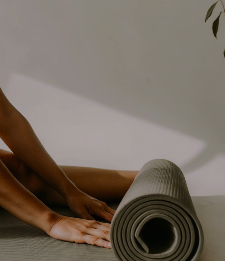 Hands rolling out a yoga mat