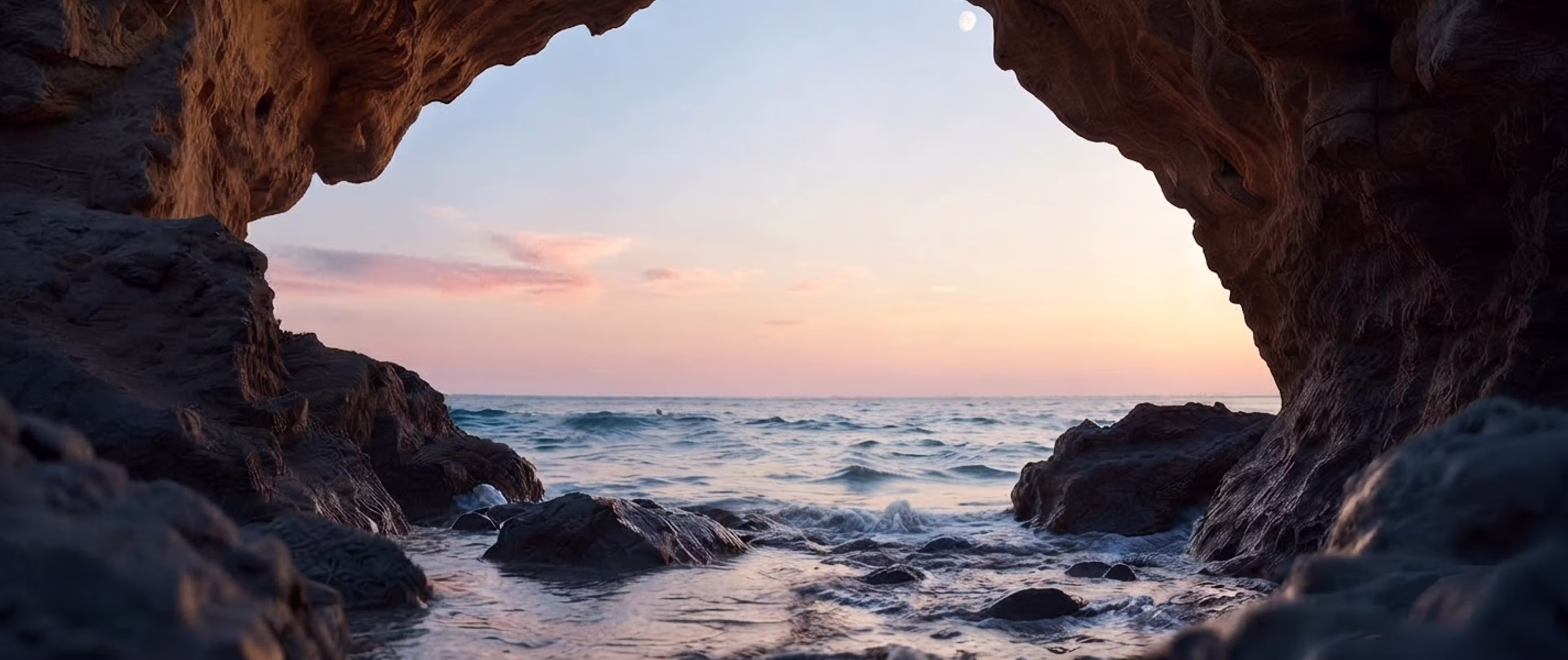 Sea cave archway opening to the ocean at sunset