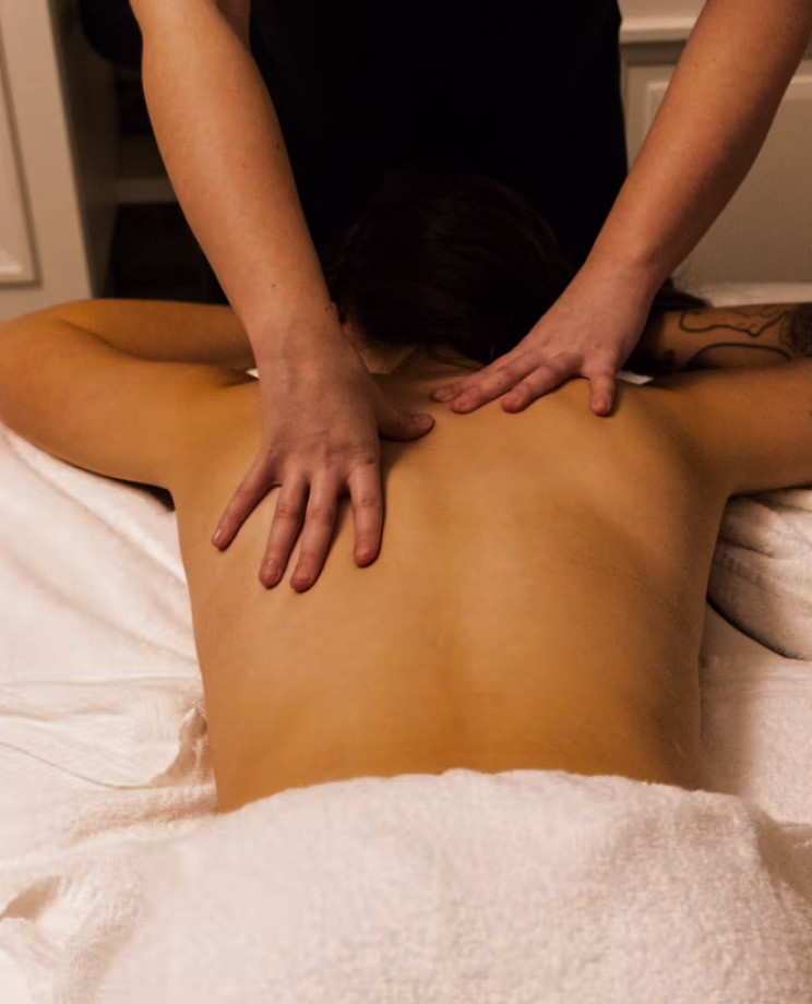 Therapist giving a back massage during a herbal apothecary treatment