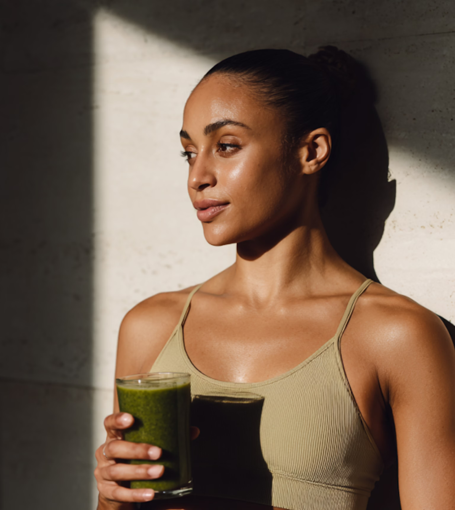 Woman relaxing with a green smoothie in soft natural light
