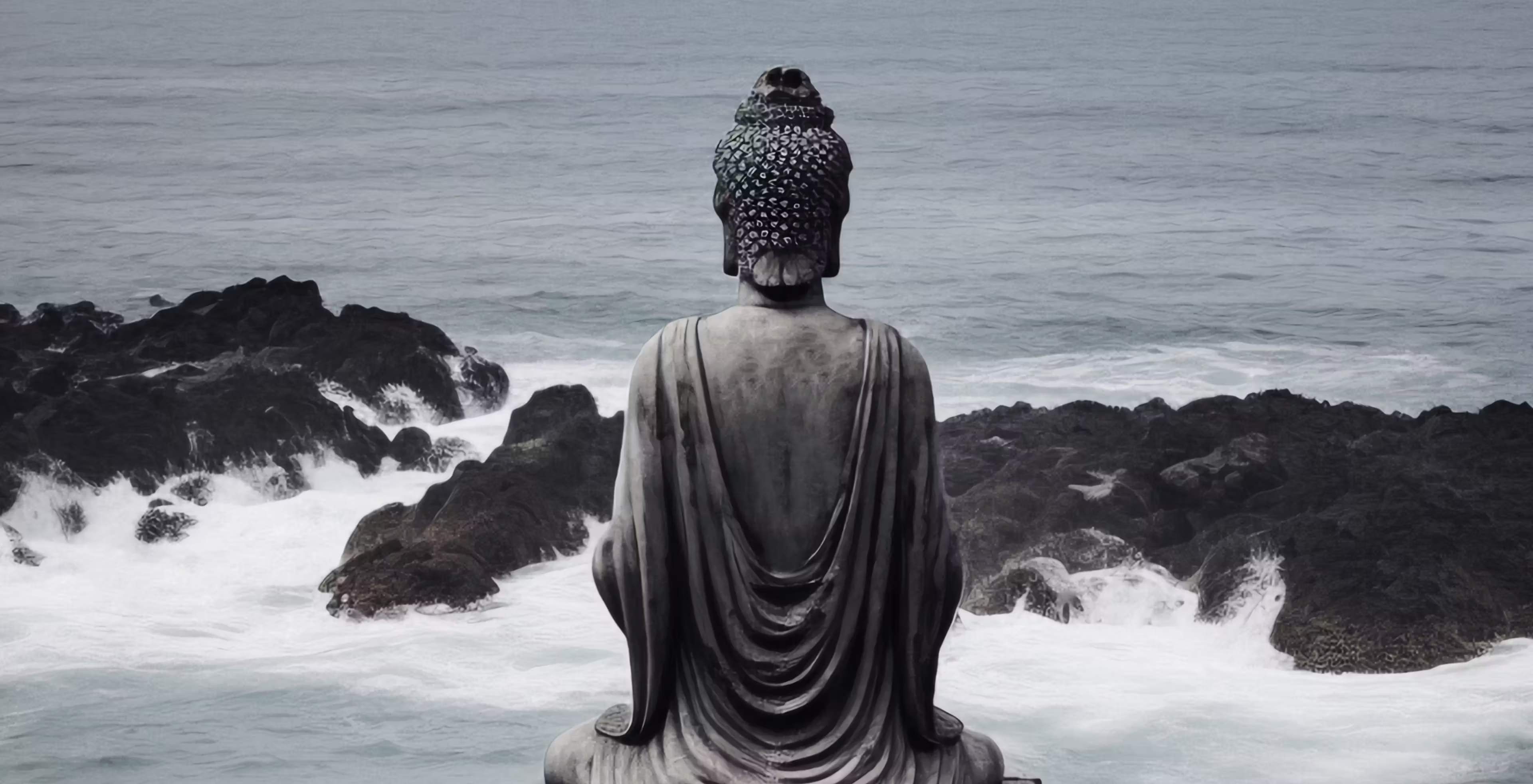 Buddha statue overlooking a calm natural water landscape