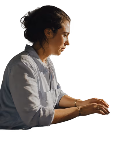 Woman in a light blue shirt typing on a keyboard against a white background.