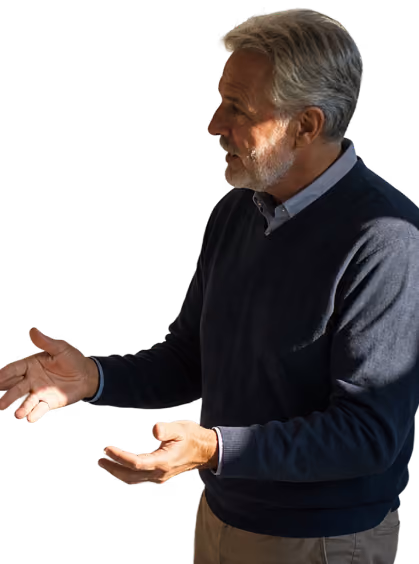 Older man with gray hair and beard gesturing with both hands while speaking.