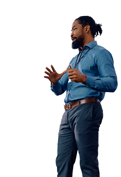 Man with beard in blue shirt and gray pants speaking with expressive hand gestures.