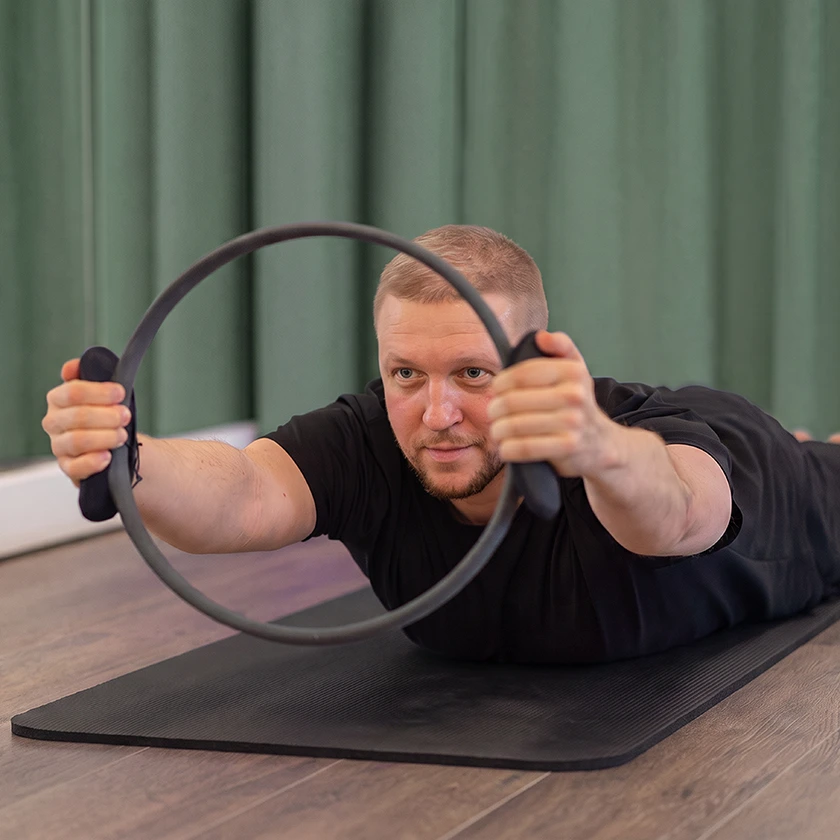 homme avec un cercle sur un tapis de pilates