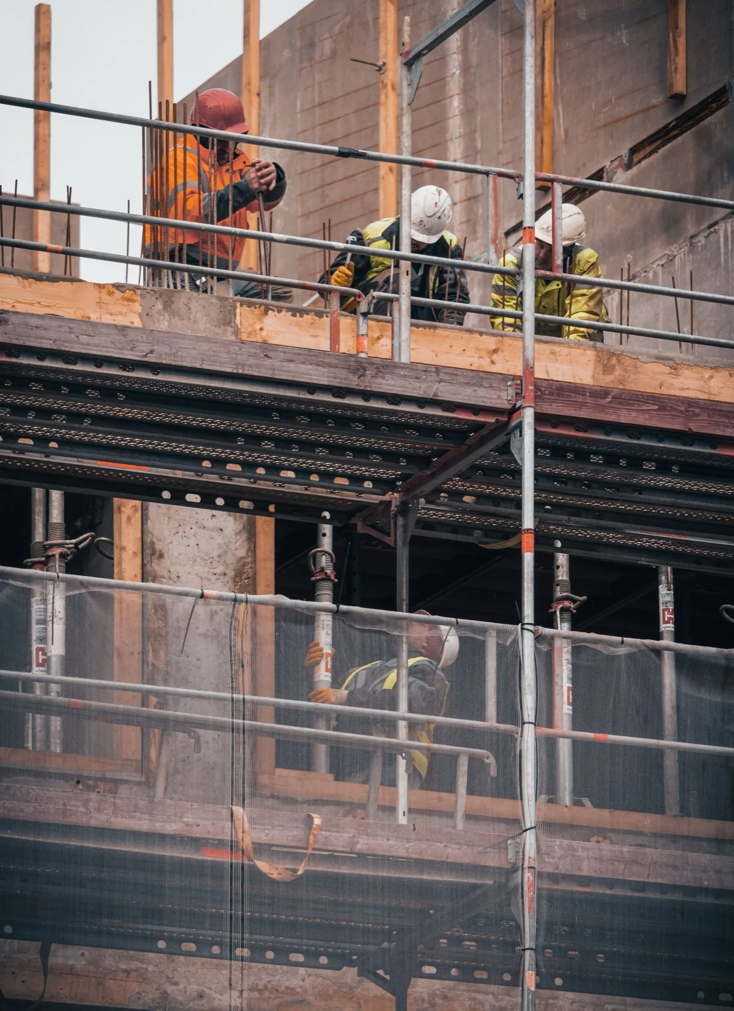 Byggarbetare på ställningen till en byggnad under uppförande