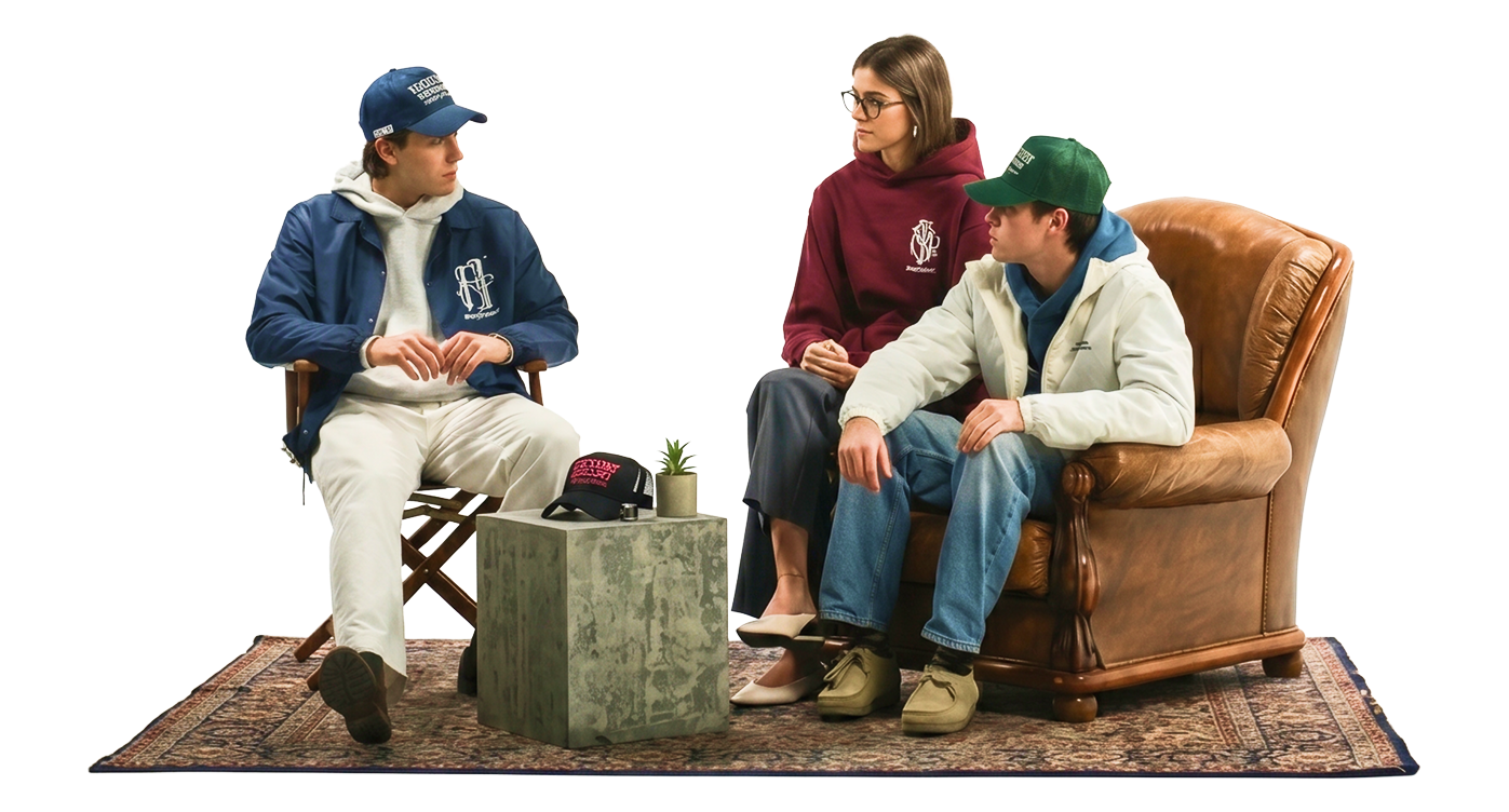 Three young people in caps and hoodies sitting together