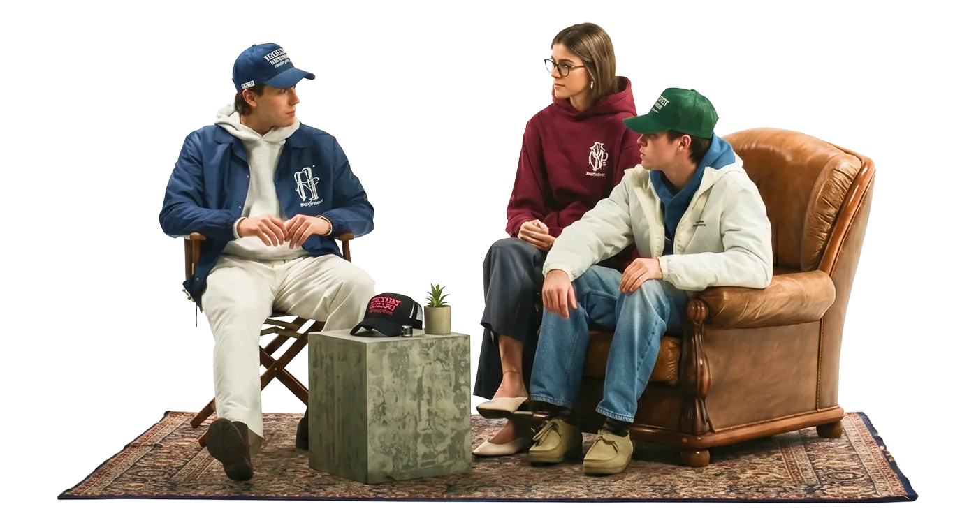 Three young people in caps and hoodies sitting together