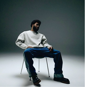 Person sitting on a stool in a studio setting